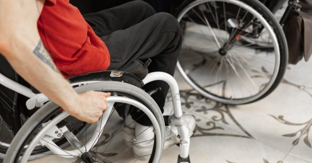 pexels-photo-7698026-7698026 Close-up of person in wheelchair wearing red shirt, indoors.